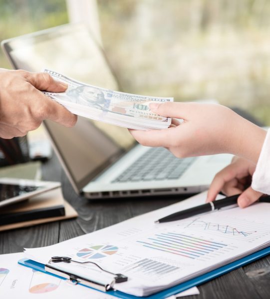 businessman giving money to his partner while making contract - bribery and corruption concepts.