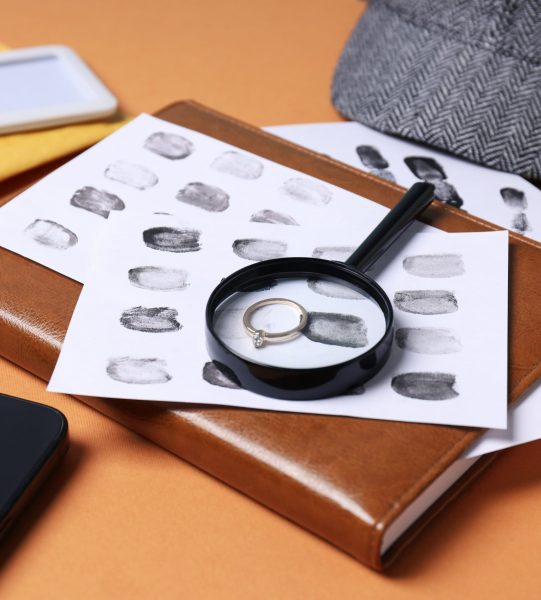 Magnifying glass with hat, fingerprints and cigarettes