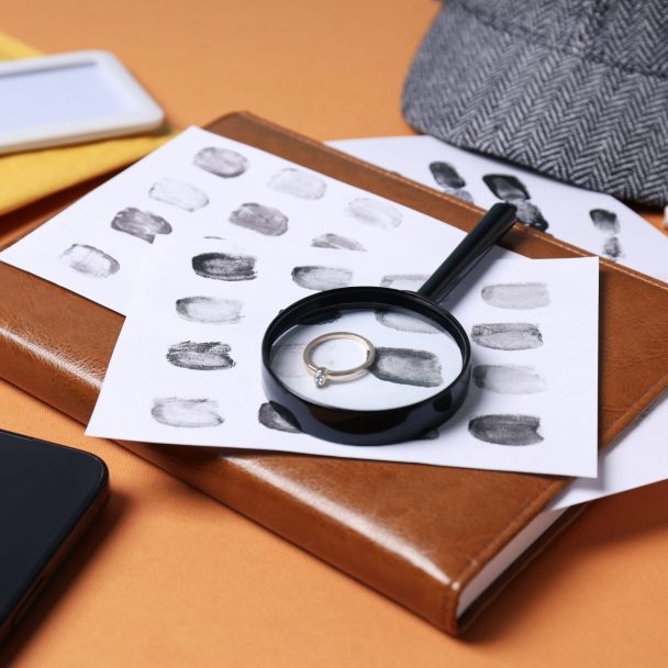 Magnifying glass with hat, fingerprints and cigarettes